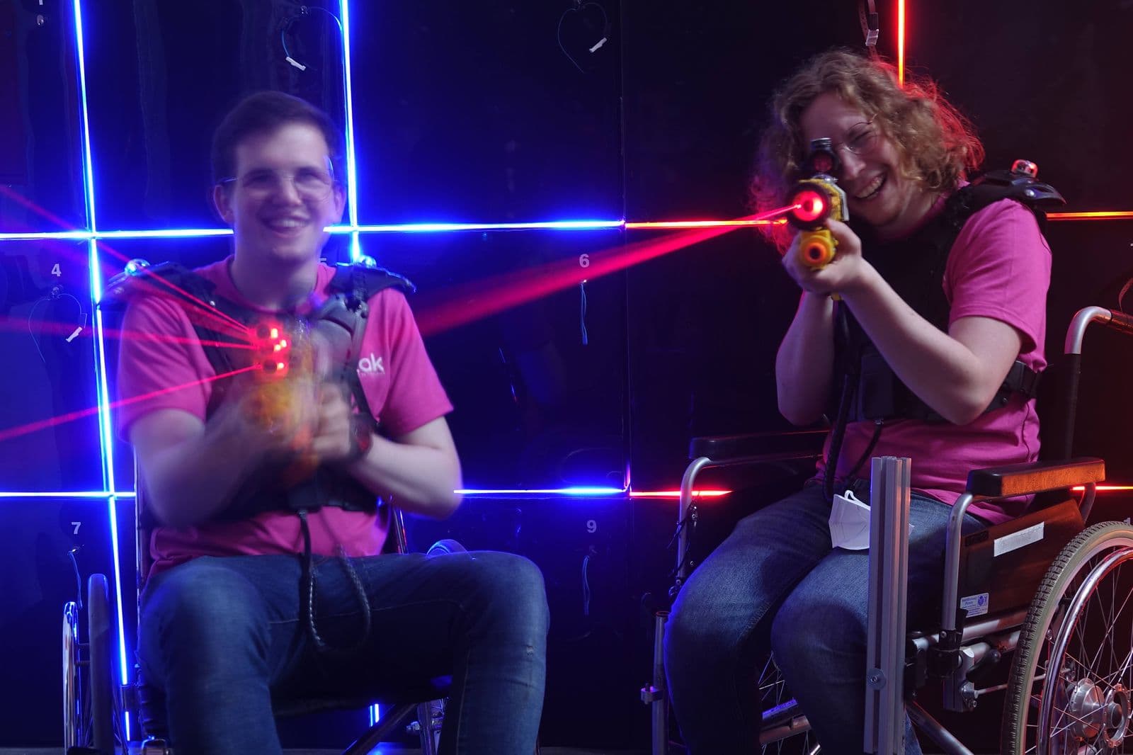 Rollstuhl-Lasertag in einer abgedunkelten Halle.